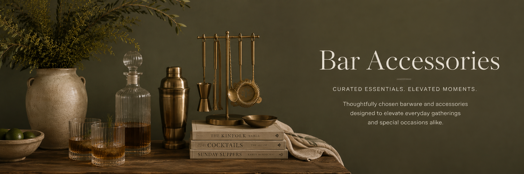 Editorial-style bar setup with glassware, brass cocktail tools, and warm moody styling