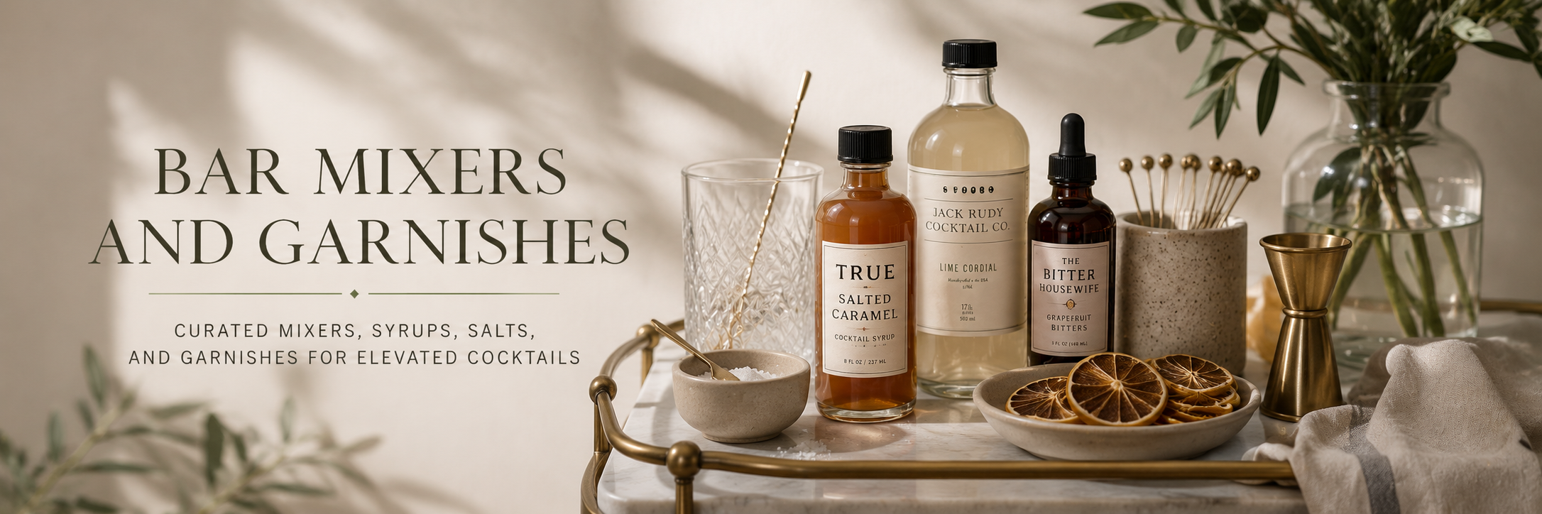 Bar mixers, cocktail syrups, salts, and garnishes styled for an elevated home bar cart.