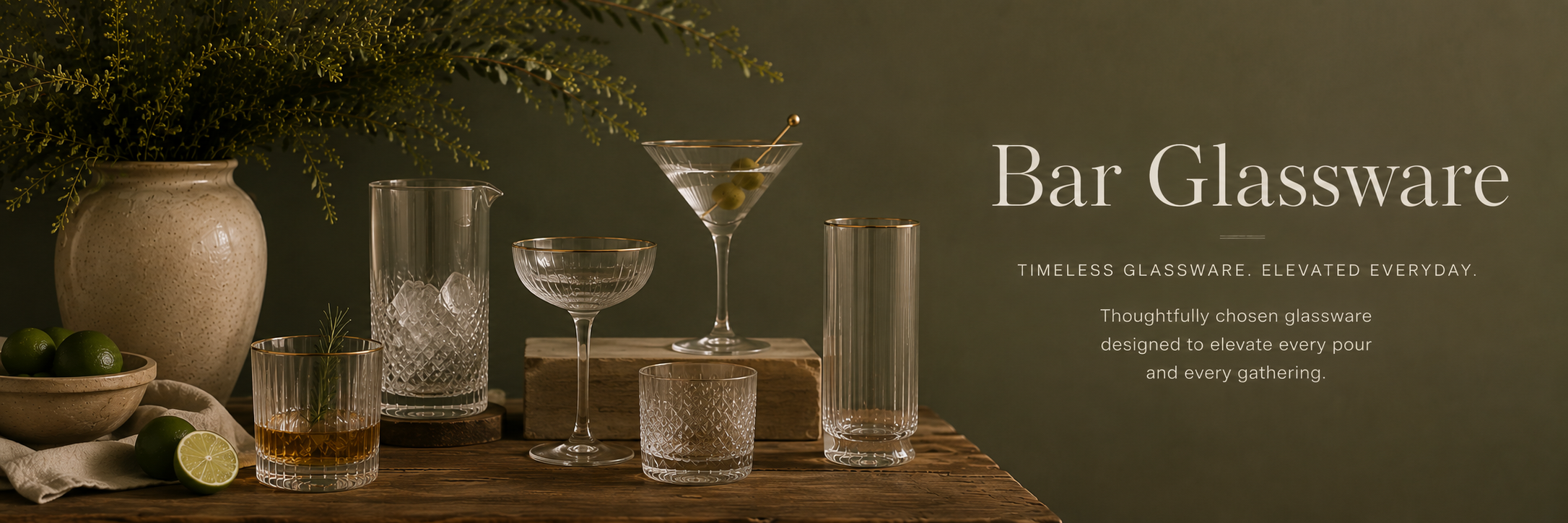 Editorial-style bar glassware collection with crystal cocktail glasses, warm olive backdrop, and refined entertaining setup