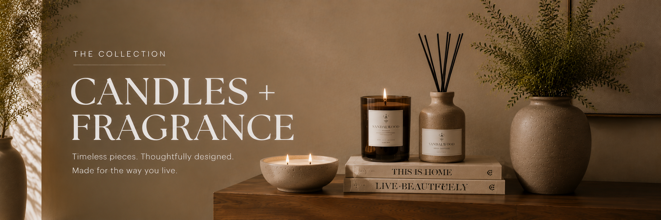 Neutral candles and home fragrance styled on a wood console with ceramics, books, and greenery in a warm, refined home setting