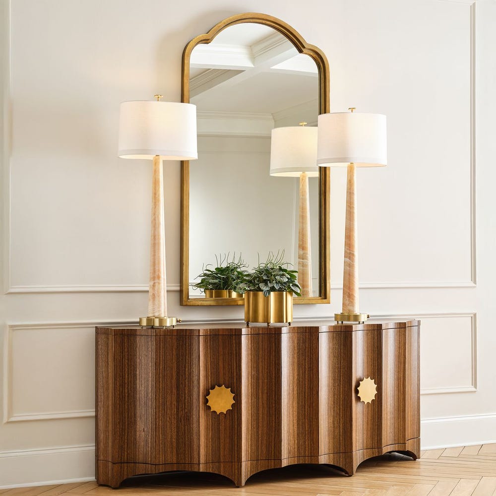 Fluted wood cabinet styled with mirror and lamps